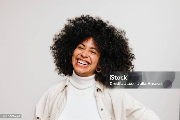 Happy Young Woman Of Color Smiling At The Camera In A Studio Stock Photo - Download Image Now