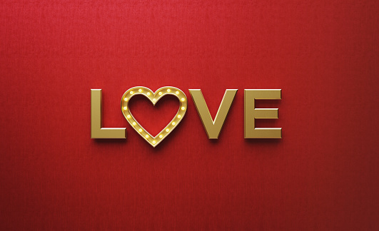 Gold colored heart shape made of light bulbs forming love word on red background. Horizontal composition with copy space. Love concept.