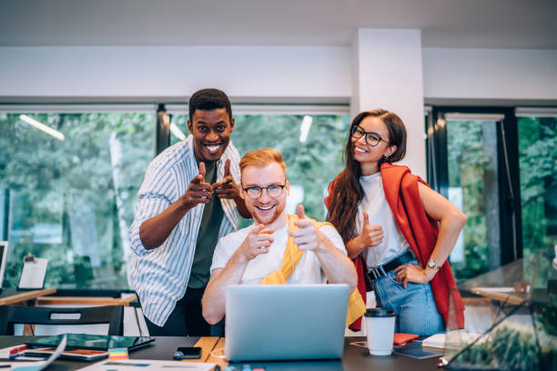 istock Cheerful multiracial colleagues smiling and pointing at camera 1432227299