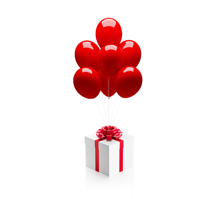 White gift box tied with red ribbon is about to be carried away by red balloons on red background. Vertical composition with copy space, Great use for Christmas and Valentine's Day related gift concepts.