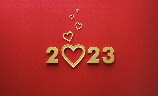 Gold colored heart shapes and 2023 over red background. Horizontal composition with copy space.