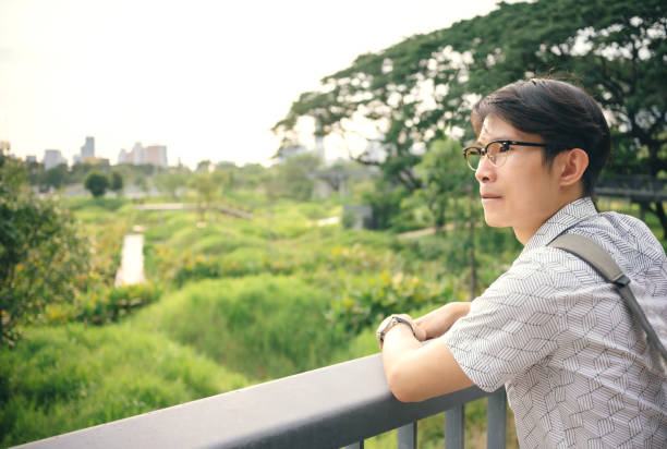 istock Asian wear glasses Looking at the sunset 1432236790