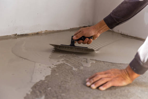 istock Grey self-leveling screed, new floor layer, man hand. 1432240174