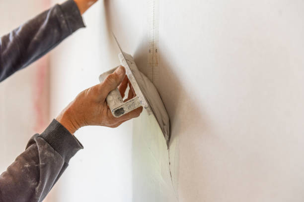 istock Old manual worker with wall plastering tools renovating house. 1432240484