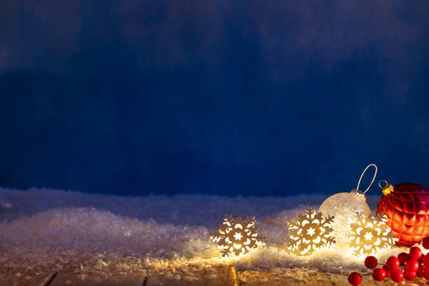 рождественский фон снежинок, светящихся в ряд на снегу - blue bauble стоковые фото и изображения