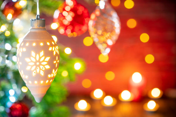 Christmas fir tree background with baubles, snowflake and glowing Christmas lights bokeh