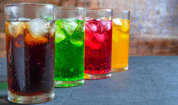 a lot of soft drinks in colorful and flavorful glasses on the table,glasses with sweet drinks with ice cubesv - frisdrank-fotos stockfoto's en -beelden