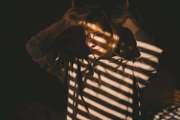 istock Woman in sunlight at the window 1432244950