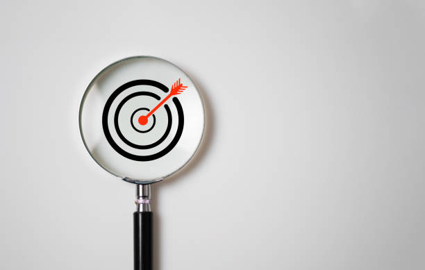 istock Target board inside of magnifier glass for focus business objective on white background and copy space. 1432245783