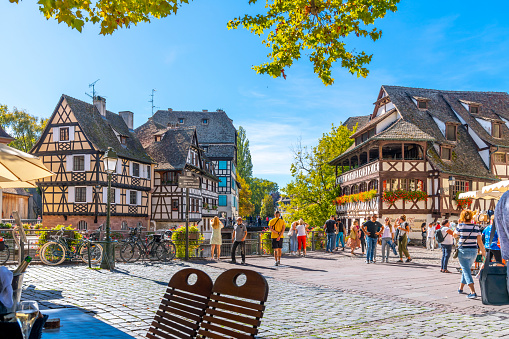 Picturesque half timbered buildings of shops, homes and cafes in the Petite France canal zone along the Ill river in the historic city of Strasbourg, in the Alsace region of France. The Maison des Tanneurs (tanners house) viewable on the riverbank
