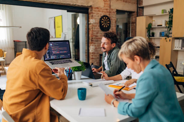 istock A small group of people learn to code programs. They look at the codes on the laptop and listen to a colleague who explains the coding technique in detail 1432249782