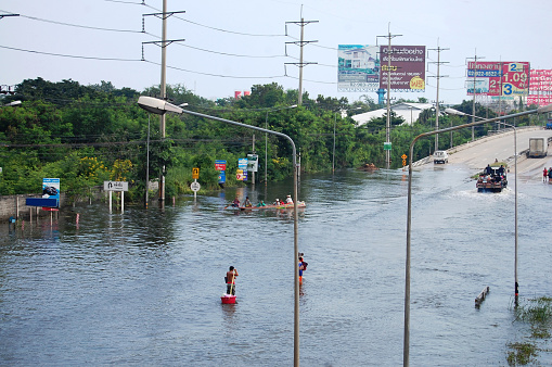 View landscape cityscape of Bang Bua Thong city while water flood and inundation road with thai people wait help rescue and donations at countryside rural in Nonthaburi, Thailand