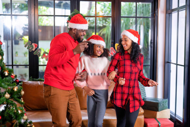 familia americana feliz riendo celebrar la víspera de navidad - los niños y los padres brindis bebidas mientras almuerza fotografías e imágenes de stock