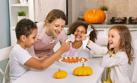 Wish you a happy Thanksgiving. The joyful guests are sitting at the table. Traditional Thanksgiving dinner with family. We instill traditions in children.