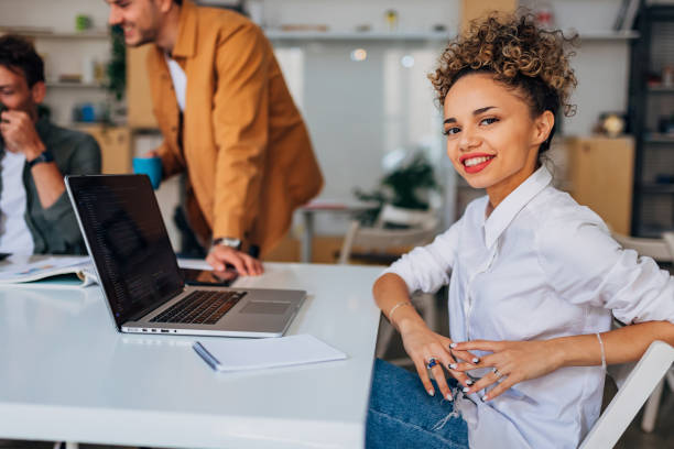 istock A Hispanic woman in a white shirt is learning to code while sitting at a conference table apart from her colleagues 1432258989