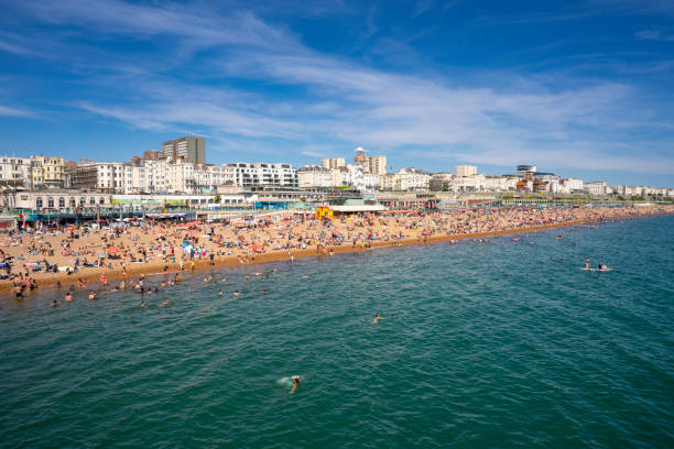 Brighton seaside resort beach in a summer sunny blue sky day with tourists in UK Brighton seaside resort beach in a summer sunny blue sky day with tourists in UK, Great Britain, England in East Sussex 47 miles south London, called as "the happiest place to live in the UK", also a LGTBIQ+ popular destination landmark brighton england stock pictures, royalty-free photos & images