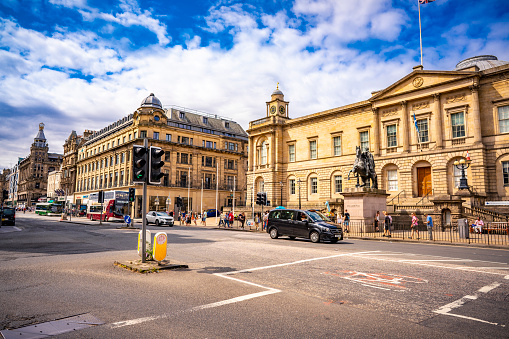 Newcastle Upon Tyne, UK, England - September 10, 2015: The Theatre Royal is a Grade I listed building situated on Grey Street in Newcastle upon Tyne.  The sky is blue and clear, and people are commuting on the street.