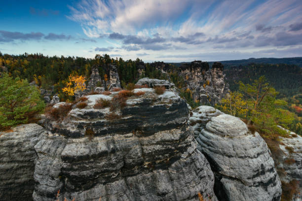 Amazing autumn landscape in Saxon Switzerland National Park. View of exposed sandstone rocks and forest hills at sunset. Germany. Saxony. stock photo