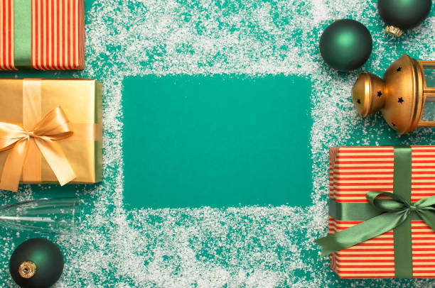 Flat lay Xmas holiday 2020 celebration. New Year Christmas presents, Christmas balls, holiday flashlight on green background with snow top view. Gift boxes greeting card Festive decorations. piso laico celebración de las vacaciones de navidad 2020. regalos de navidad de año nuevo, bolas de navidad, linterna navideña sobre fondo verde con vista a la cima de la nieve. cajas de regalo tarjeta de felicitación decoraciones festivas