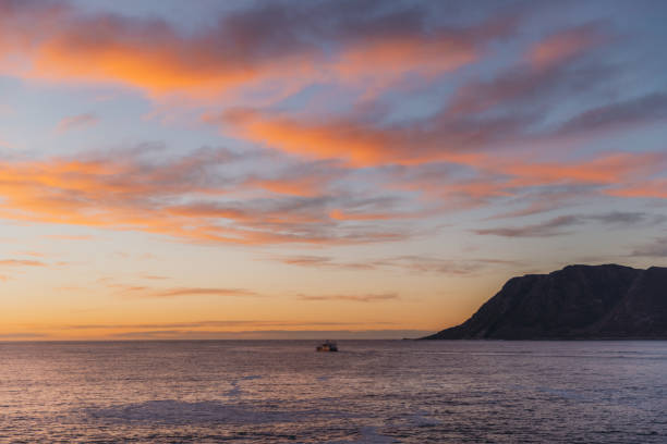 Silhouette of a boat in the sea during dramatic colorful pink sunset