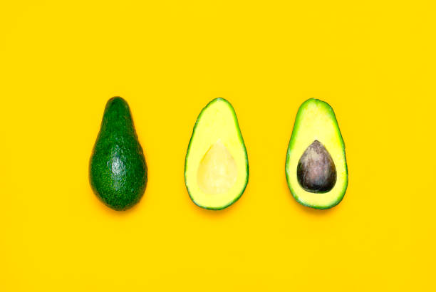 istock Ripe sliced avocado on bright yellow background top view. Creative food composition Flat lay. Pop art design, tropical summer abstract background with avocado. Green avocadoes pattern, diet concept 1432276791