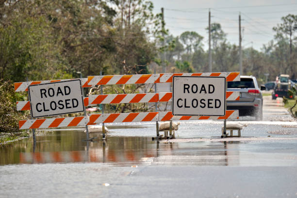 carretera cerrada por obras viales y peligro de inundación con señales de advertencia que bloquean la conducción de automóviles - ahogar fotografías e imágenes de stock