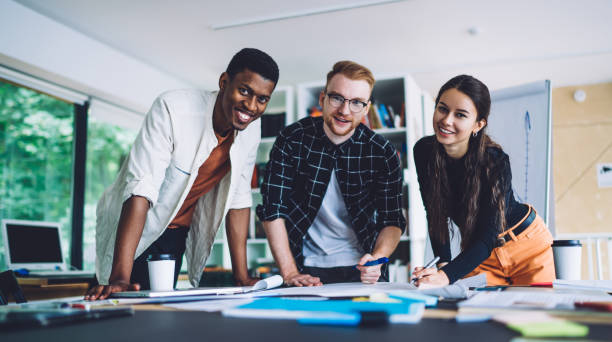 istock Cheerful multiethnic architects smiling and looking at camera in office 1432277050