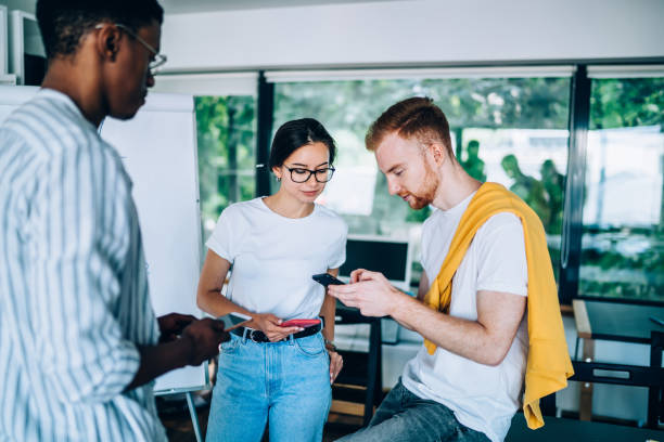 istock Young colleagues surfing cellphones in workspace 1432277270