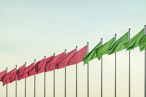 A row of colorful flags fluttering in the wind in the sun