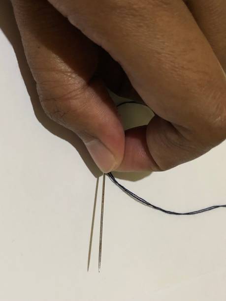 istock photo of hands holding needles for sewing 1432279396