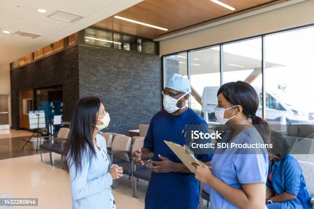 Anxious Female Family Member Talks To Er Doctor And Nurse Stock Photo - Download Image Now