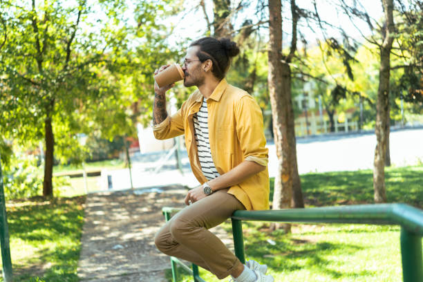 Portrait of a young man enjoying coffee break in the park