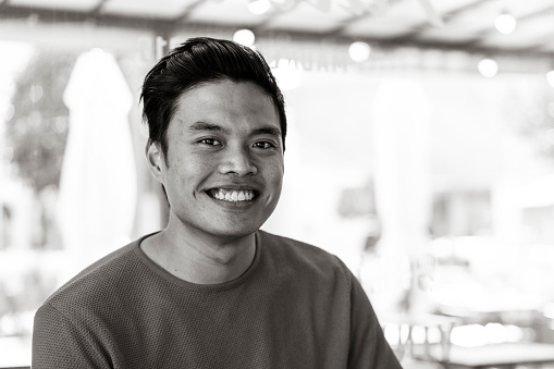 Young asian man smiling on camera indoor - Vintage filter with focus on face