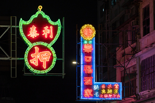 Hong Kong - October 10, 2022 : Lee Tai Pawnshop and Lok Hau Fook Restaurant signboards in Kowloon City, Hong Kong. Signboards that are hanging over the street have been disappearing rapidly in Hong Kong.