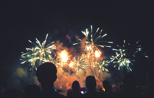 Crowd of Silhouetted People Watching a Colorful Fireworks Display at Night for New Years, Fourth of July or Independence Day Holiday Celebration Event, Horizontal, Copy Space