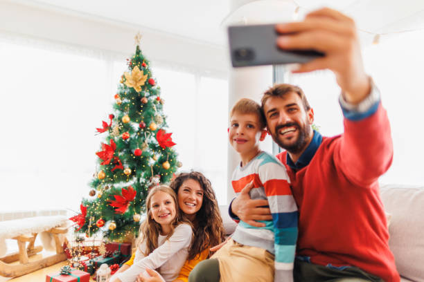 istock Happy family taking selfies by the Christmas tree 1432290838