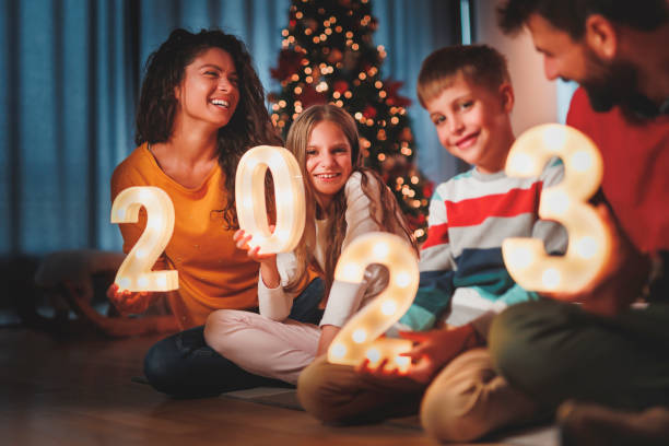 istock Parents and children holding illuminative numbers 2023 while celebrating New Year 1432290957