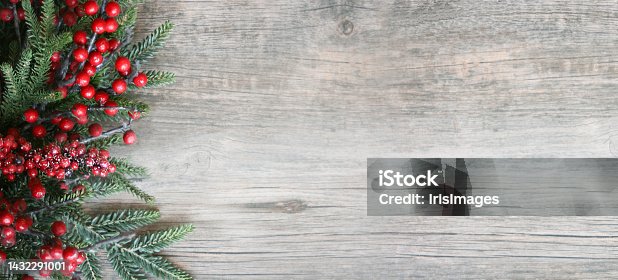istock Christmas and New Year Holiday Evergreen Fir Branches and Red Winter Berries Over Wood Panoramic Background Shot from Above 1432291001