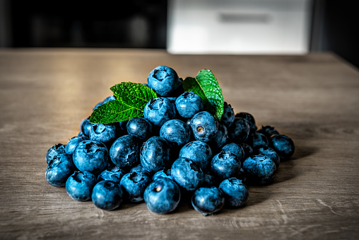 Heap of ripe blueberries with mint leaves on the table