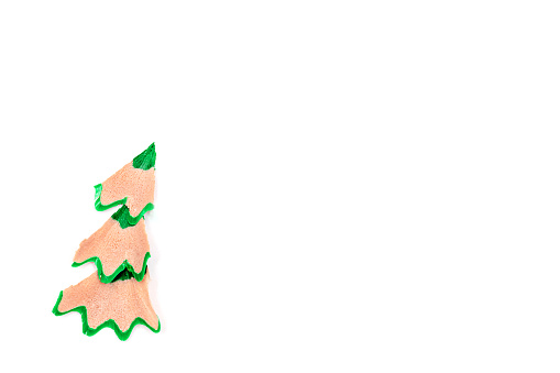 Creative Christmas tree made of shavings from a green pencil.Christmas and New Year flat lay on a white background.Copy space for text.