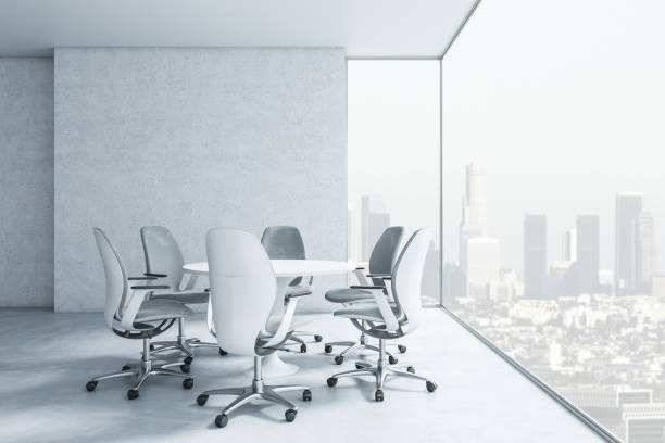 istock Side view on stylish round conference table with chairs in empty office area on high floor with city view from transparent wall. 3D rendering 1432293051