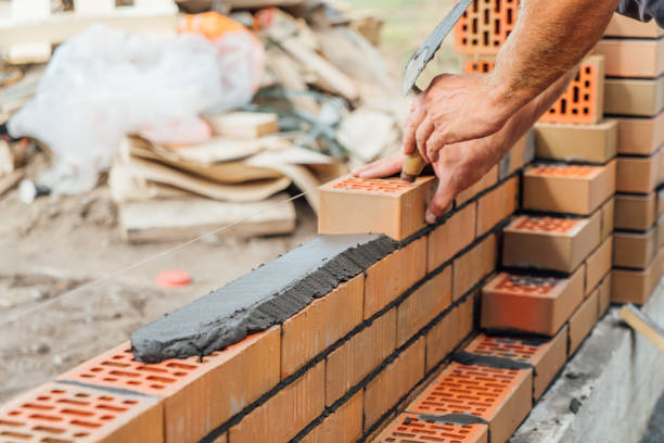 mason-kellen schmieren zementmörtel auf ziegel. maurerarbeiten beim bau von haus- oder steinzaun - brickwork stock-fotos und bilder