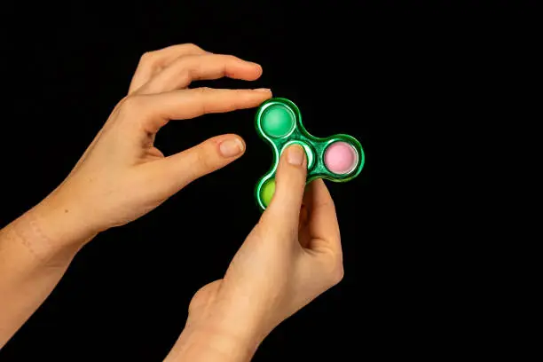 Photo of Child playing with a spinning fidget toy