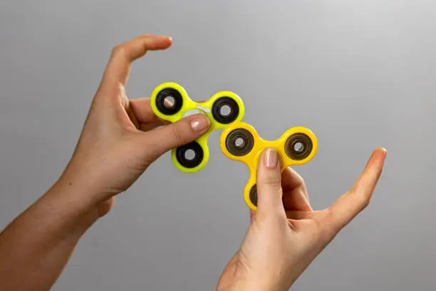 Photo of Child's hand playing with a fidget spinner toy