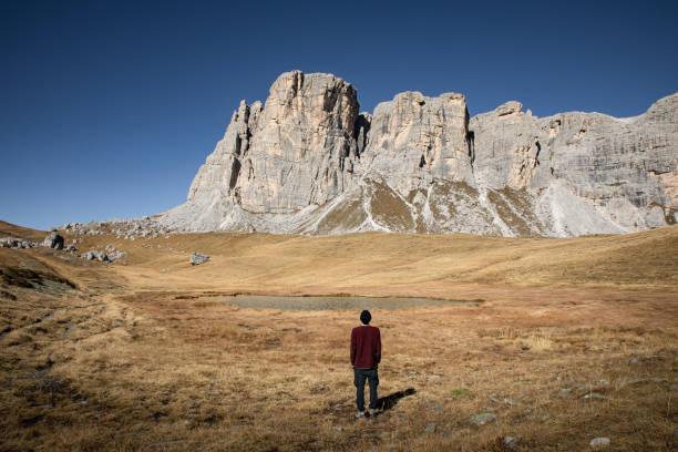 A person looking at the mountain landscape in Belluno, Italy. Relaxing image of autumn landscape at high altitude