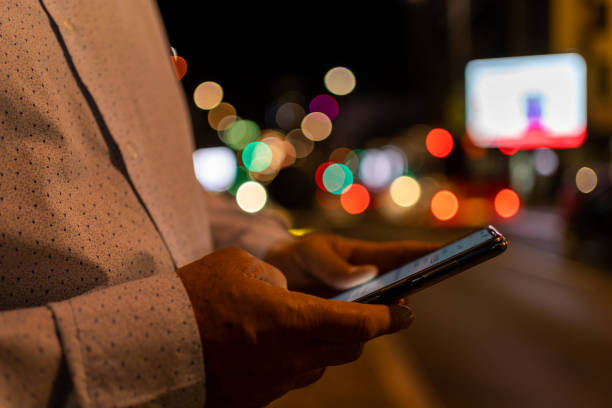 istock Human hands using smartphone in city at night time 1432295363