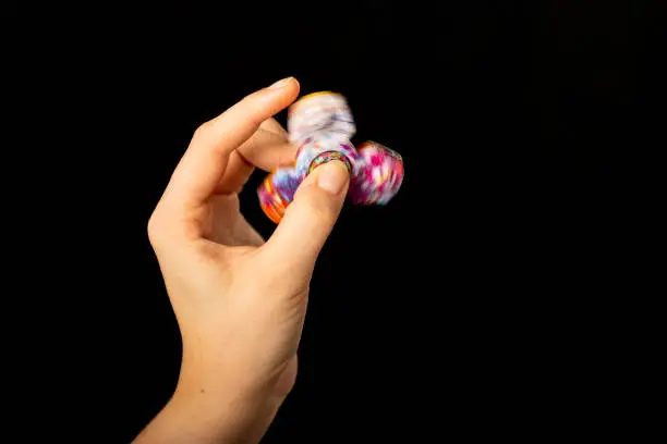 Photo of Child's hand playing with a fidget spinner toy