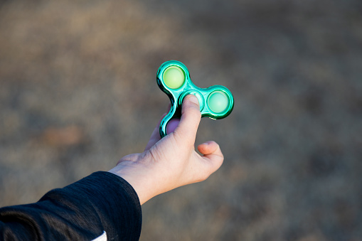 Child playing with a spinning fidget toy