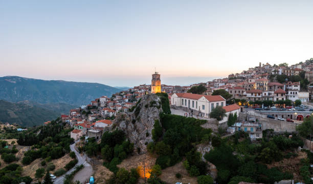 Arachova Greece mountain town aerial drone view. Traditional houses in the evening Arachova Greece mountain town aerial drone view. Traditional houses and illuminated stone tower clock, in the evening. arachova greece stock pictures, royalty-free photos & images