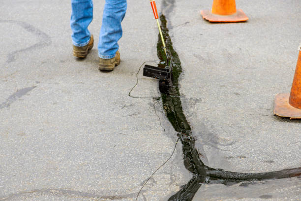 An asphaltic joint crack needs to be sealed in the restoration work of the asphalt road surface stock photo
